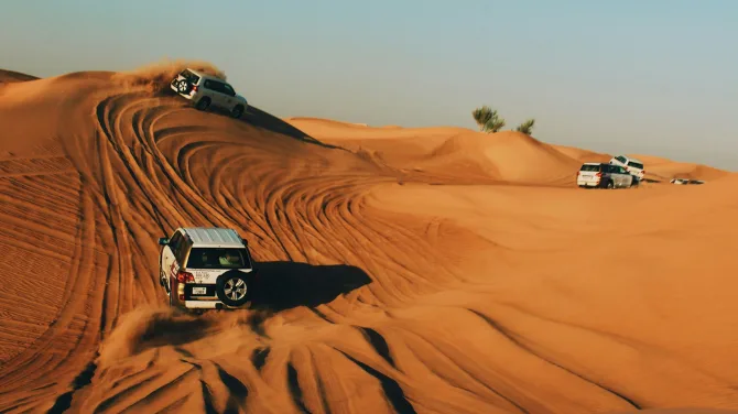 Best desert safari Dubai dune bashing with 4x4 SUV driving on golden sand dunes in UAE desert